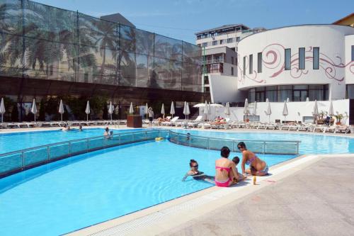 a group of people sitting in a swimming pool at Studio Residence Militari M2 in Bucharest