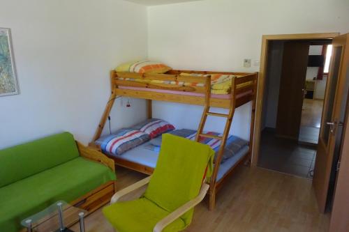 リプノ・ナト・ヴルタヴォウにあるApartmán Riviera 500/23の二段ベッド2台、ソファ、椅子が備わる客室です。