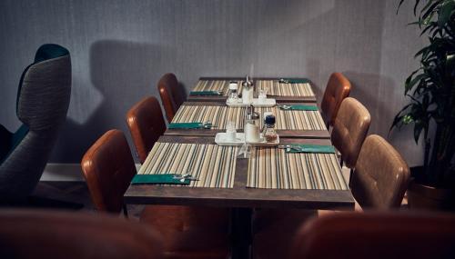 a table in a restaurant with chairs and a table set for dinner at Singel Hotel Amsterdam in Amsterdam