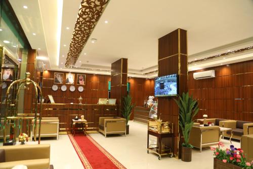 a store lobby with tables and chairs and a television at Golden Rest Serviced Apartments in Al Khobar