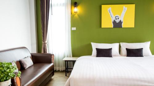 a hotel room with a bed and a couch at The Rodman Hotel in Chiang Mai