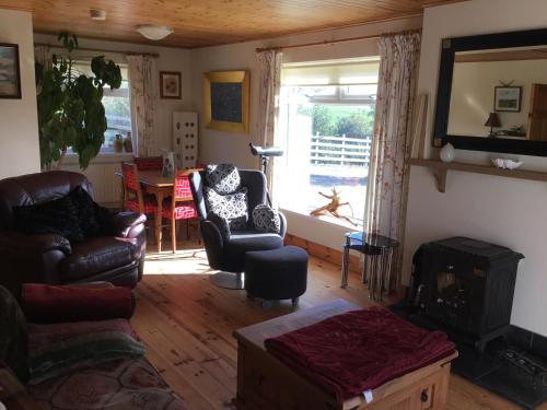 sala de estar con 2 sillas y chimenea en Hornhead Mews, Hornhead, en Dunfanaghy