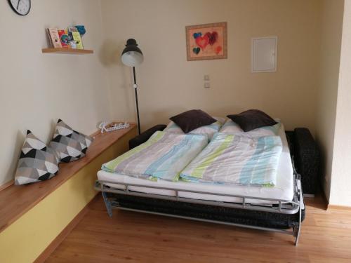 a bed sitting in a room with a lamp at Ferienwohnung Jo Secco in Bruttig-Fankel