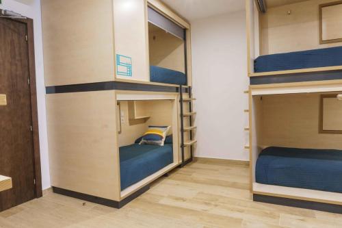 a bunk bed in a room with blue bunk beds at TAKE SURF Hostel Conil in Conil de la Frontera