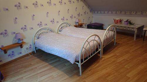 a bedroom with a bed and a wooden floor at Les Chambres du Relais in Liettres