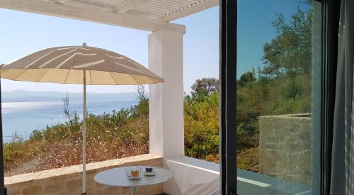 a table with an umbrella in front of a window at Galini Breeze in Agia Galini