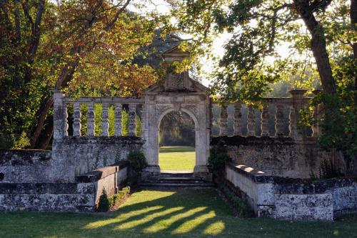 an archway in a stone fence with a grass yard at Château De La Bourdaisière in Montlouis-sur-Loire