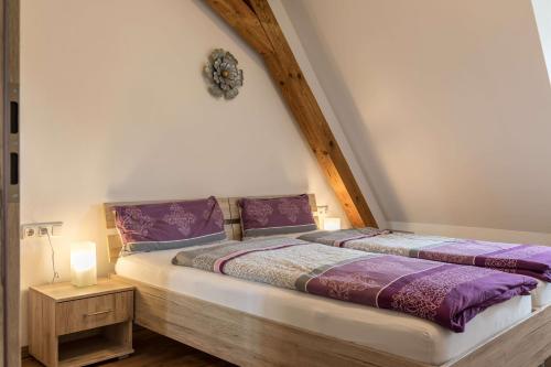 1 Schlafzimmer mit 2 Betten und lila Bettwäsche in der Unterkunft Ferienwohnung Zetzl in Waidhaus