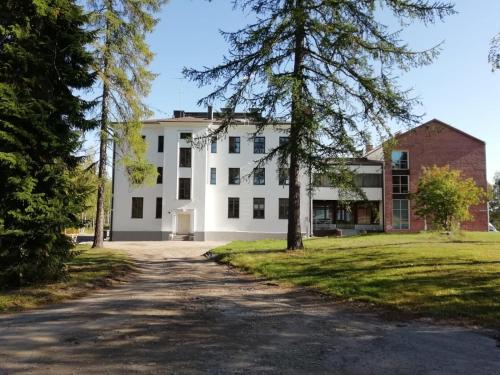 um grande edifício branco com árvores em frente em Hotel Metsähirvas em Rovaniemi