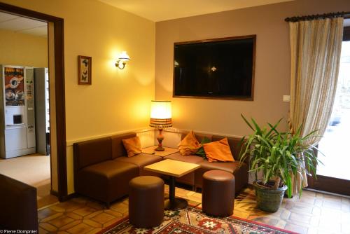 a living room with a couch and a table at Hôtel Saint-Georges in Saint-Jean-de-Maurienne