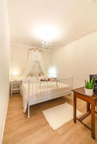 a white bedroom with a bed with a canopy at il risveglio di alice in Fano