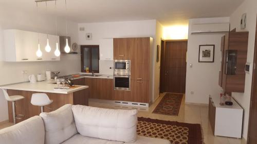 a living room with a white couch and a kitchen at Gianni Holiday Home in Pieta