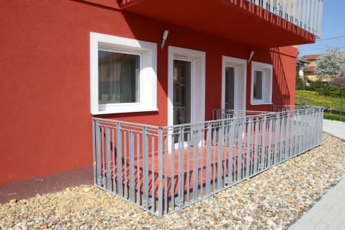 a red building with a balcony on the side of it at Zala Aranya Panzió in Zalakaros