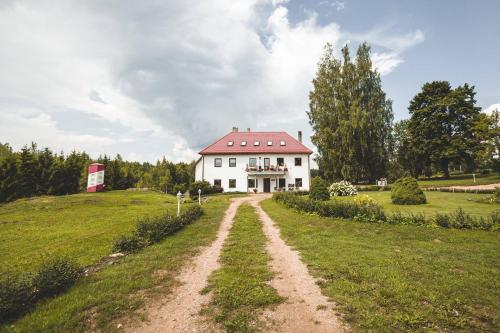 a house on a hill with a dirt road at Šubrakkrasti in Vestiena