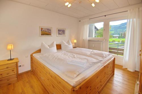 a large bed in a room with a large window at Rubihorn in Fischen
