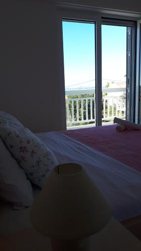 a bedroom with a bed with a view of a balcony at Apartment Dana in Zadar