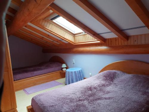 a attic room with two beds and a skylight at châlet in Ferdrupt
