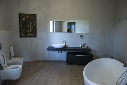 uma casa de banho com um lavatório, um WC e um espelho. em Un sogno che si avvera em Gorizia