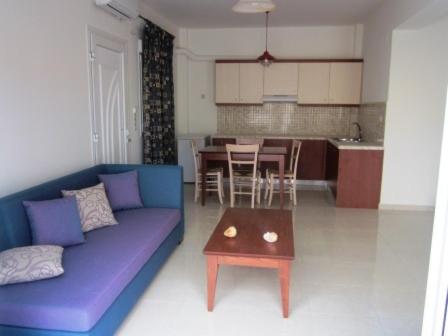 a living room with a purple couch and a table at 4S Beach Superior Apartments in Stalida