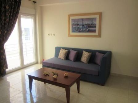 a living room with a blue couch and a coffee table at 4S Beach Superior Apartments in Stalida