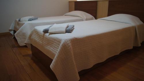 Dos camas en una habitación con toallas. en Alojamento Rural de Covelas, en Covelas