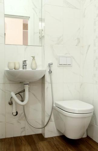 a white bathroom with a sink and a toilet at Apartments Astoria HN in Herceg-Novi