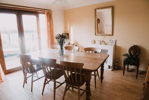 een eetkamer met een houten tafel en stoelen bij Greenbank Bed & Breakfast in Montrose