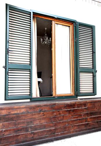 a window with green shutters on a building at Apartments Astoria HN in Herceg-Novi