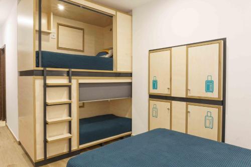 a small room with bunk beds and a bed at TAKE SURF Hostel Conil in Conil de la Frontera