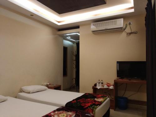 una camera con due letti e una TV e una camera di Bottomhill Palace Hotel a Sylhet