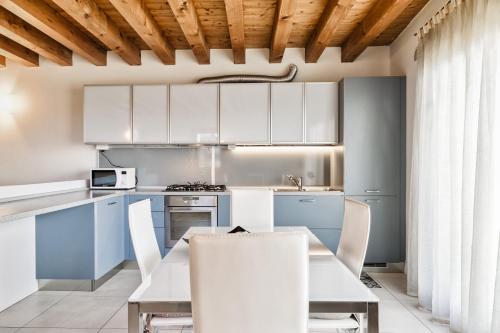 cocina con armarios blancos, mesa y sillas en CASA GIORGIA - NEL CUORE DI VICENZA en Vicenza