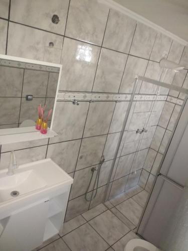 a bathroom with a shower and a sink at Casa Camioto in Olímpia