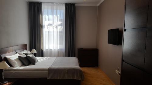 リヴィウにあるSoprano Apartment Tamanskaのベッドと窓が備わるホテルルーム