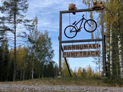 a sign with a bike on it next to a forest at Saimaa Style Spa Chalet in Imatra