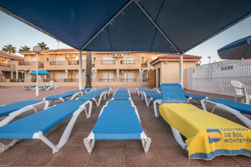 a group of blue and white chairs and a building at Destinos De Sol Los Alcazares - Montepío Minería in Los Alcázares