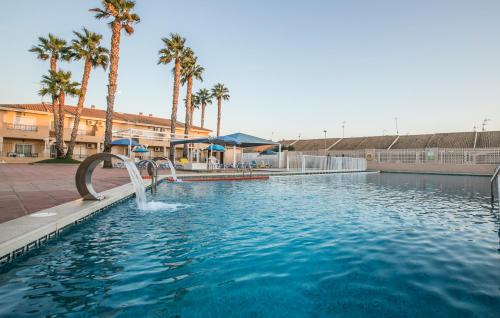 a water slide in a swimming pool with palm trees at Destinos De Sol Los Alcazares - Montepío Minería in Los Alcázares