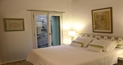 1 dormitorio con 1 cama blanca grande con almohadas blancas en Villa Tripotamos, en Tripótamos
