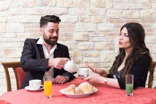a man and woman sitting at a table drinking tea at Hotel Centrale in Gambarie dʼAspromonte