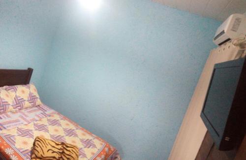 ein Schlafzimmer mit einem Bett und einer blauen Wand in der Unterkunft Pousada da Guarda in Guarda do Embaú