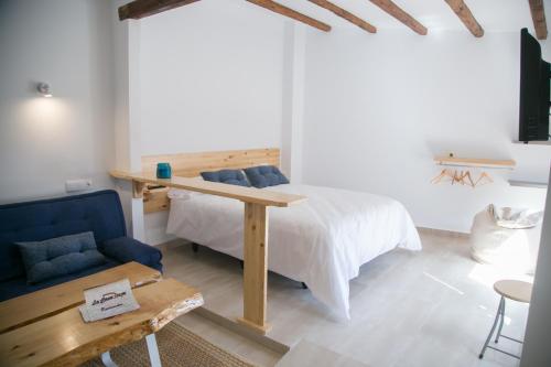 Un dormitorio con una cama, una mesa y un sofá. en Apartamentos Turísticos La Casa Vieja, en Sabiote