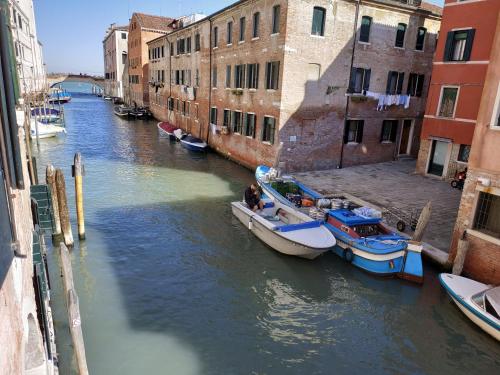 zwei Boote sind in einem Kanal mit Gebäuden angedockt in der Unterkunft Alloggi Acquavita - checkin at "Alloggi SS Giovanni e Paolo" in Venedig