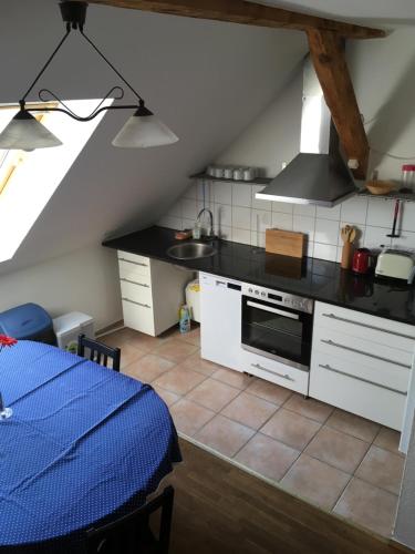 a kitchen with white cabinets and a stove top oven at Storchenblick in Straupitz