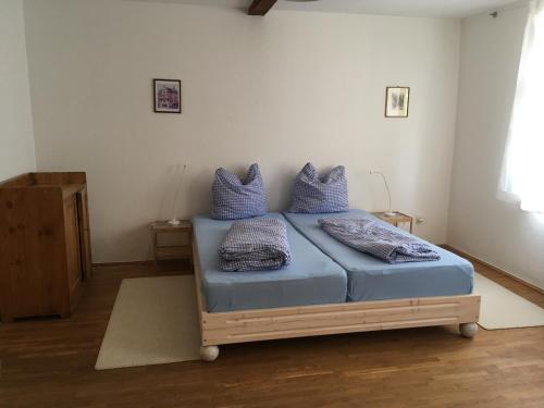 una camera da letto con letto con lenzuola e cuscini blu di Storchenblick a Straupitz
