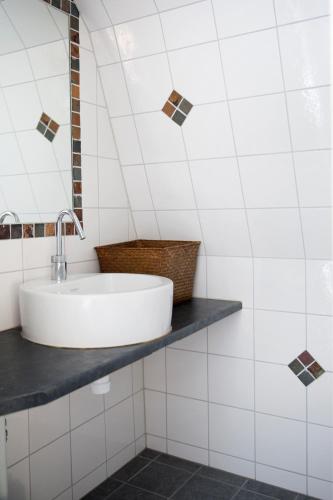 a white bathroom with a sink and a mirror at Mullbärsgårdens Bed and Breakfast in Visby