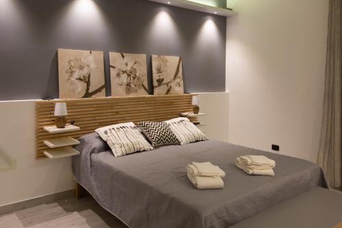 a bedroom with a bed with two towels on it at UP&B Rooms Catania in Mascalucia