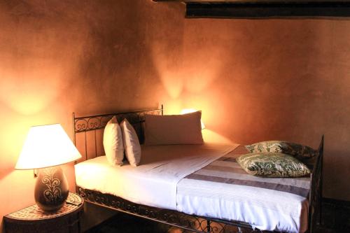 a bedroom with a bed with a lamp and pillows at Masseria & Spa LuciaGiovanni in Lecce