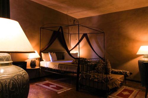 a bedroom with a canopy bed and a lamp at Masseria & Spa LuciaGiovanni in Lecce