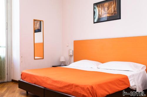 a bedroom with a large bed with an orange headboard at Hotel Youri Il Magnifico in Genova