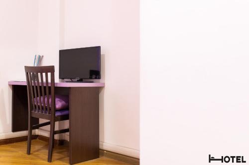 a computer desk with a chair and a computer monitor at Hotel Youri Il Magnifico in Genova