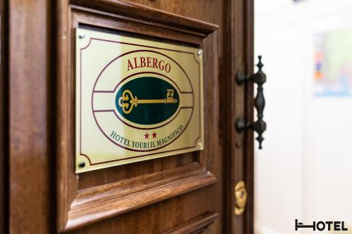 a sign on a wooden door with a albergo logo at Hotel Youri Il Magnifico in Genova